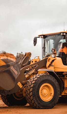 yellow and black heavy equipment on brown field during daytime