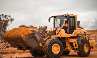 yellow and black heavy equipment on brown field during daytime