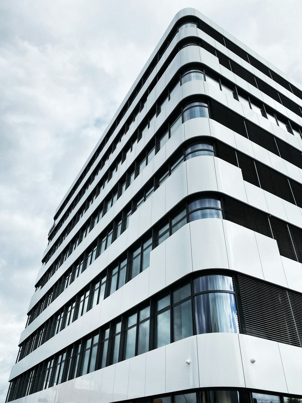 white concrete building under white clouds during daytime