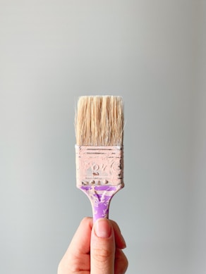 person holding brown and gray paint brush