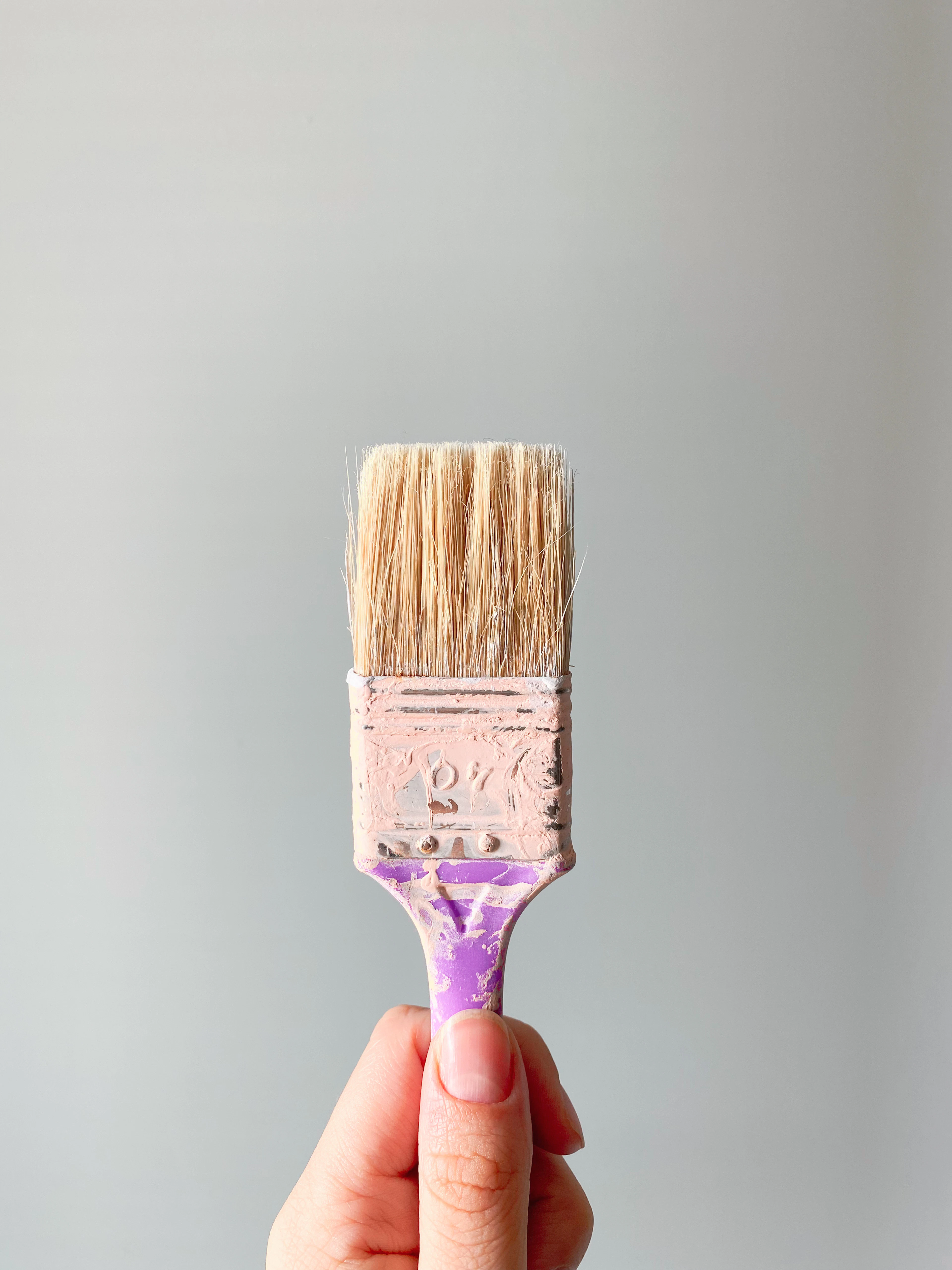 Hand holding a paint brush