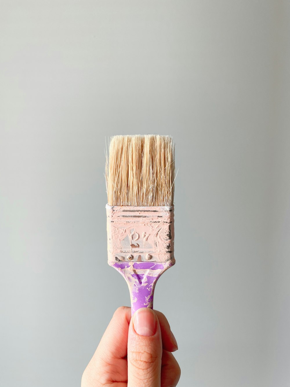 person holding brown and gray paint brush