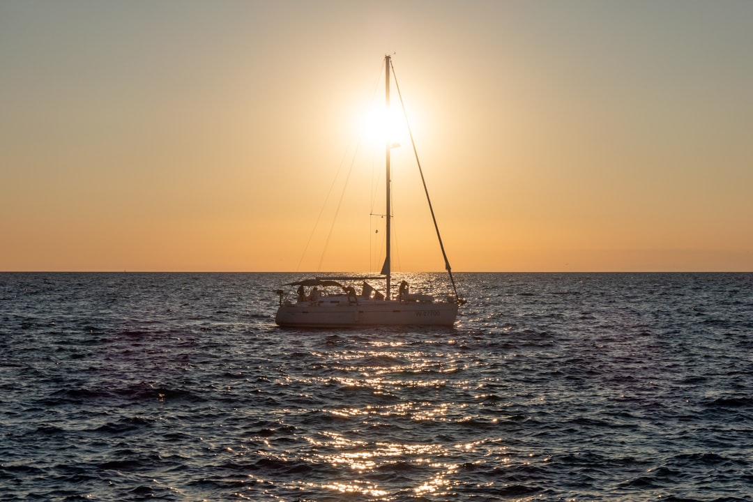 white boat on sea during sunset