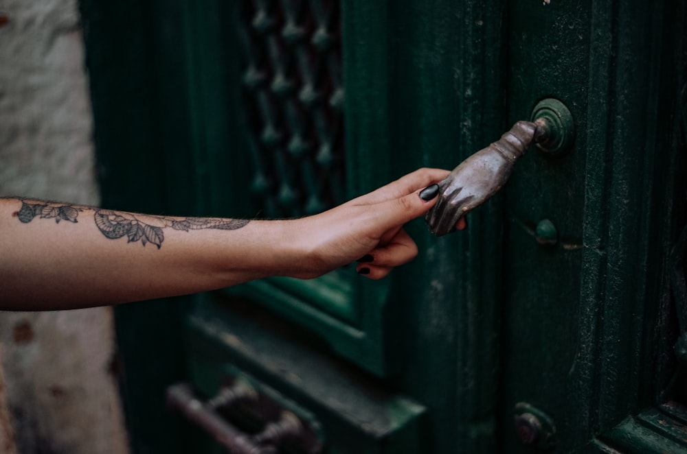 person holding green metal pipe