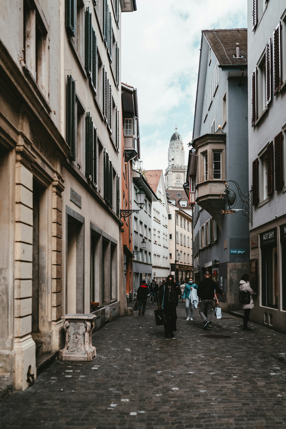 people walking on street between buildings during daytime