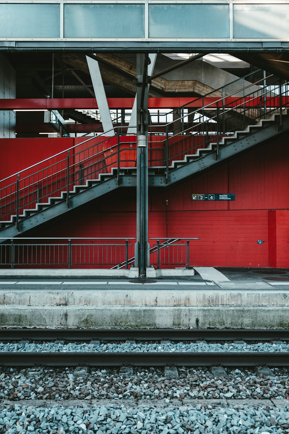 red metal railings near gray concrete road