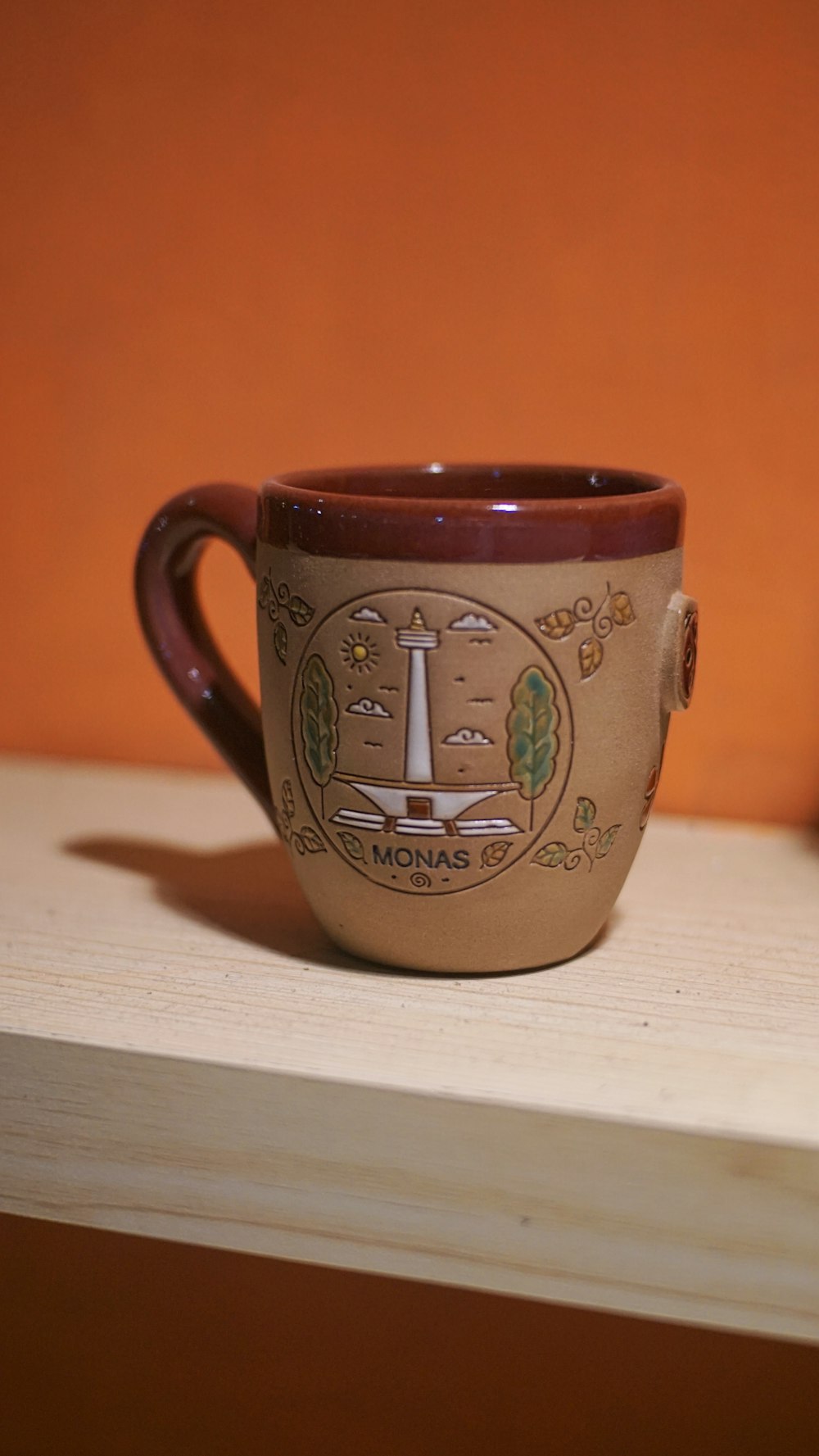 brown and green ceramic mug