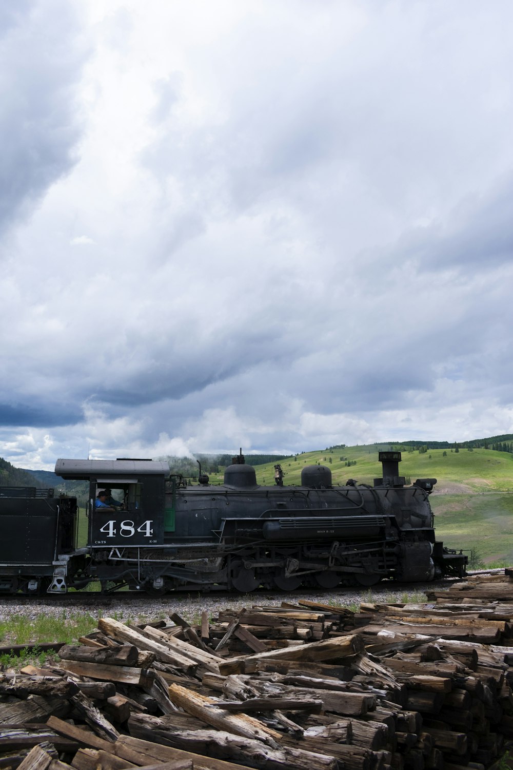 green and black train under white clouds during daytime