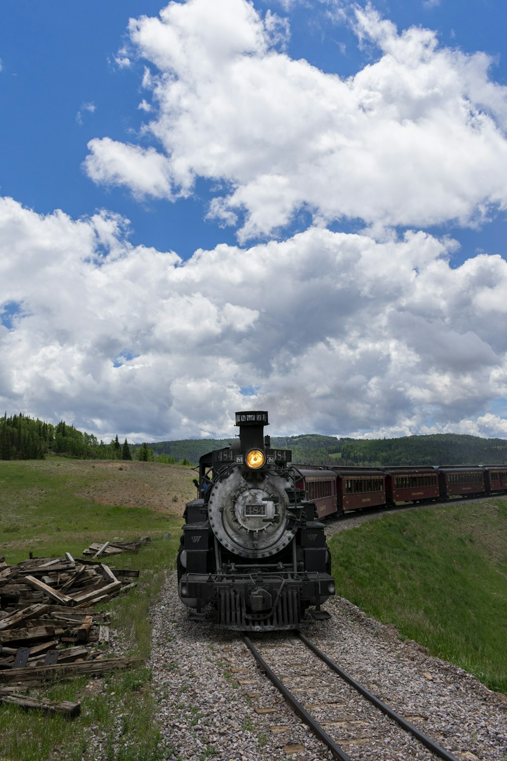 black train on rail under cloudy sky during daytime