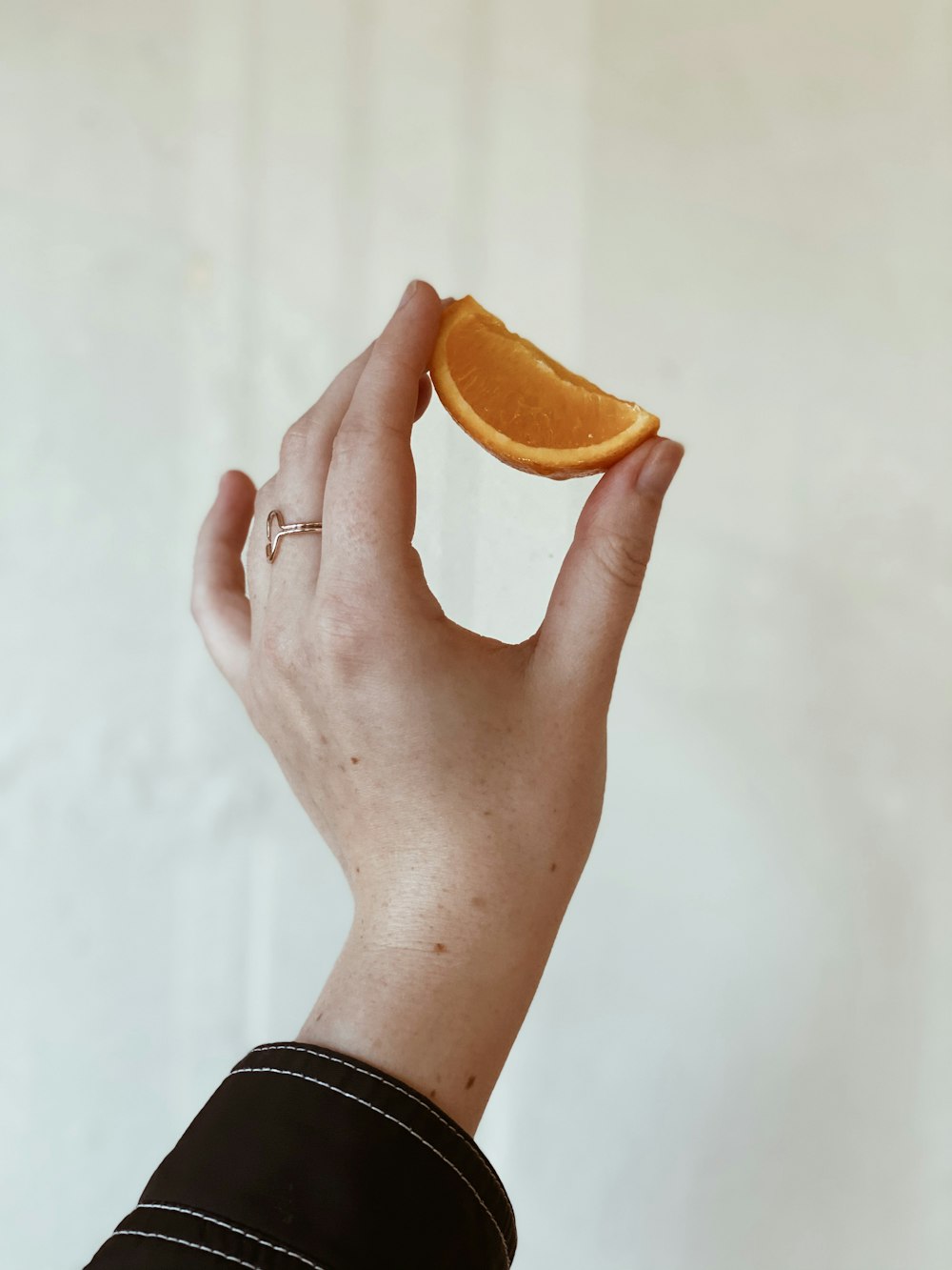 person holding sliced orange fruit