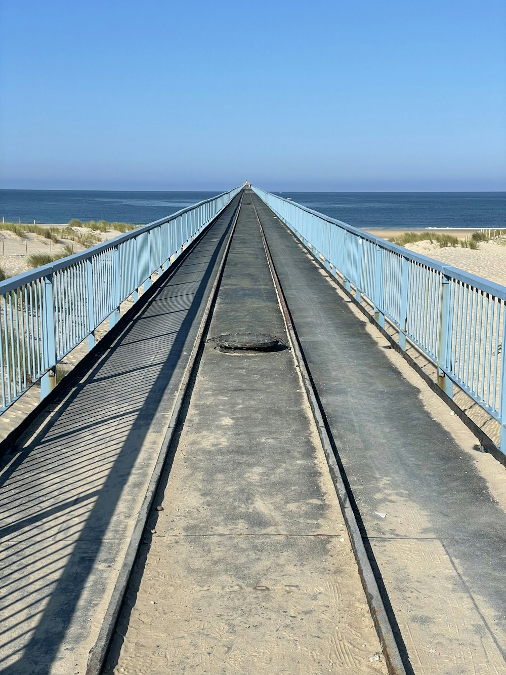 gray metal bridge under blue sky during daytime