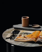 white ceramic mug on brown book