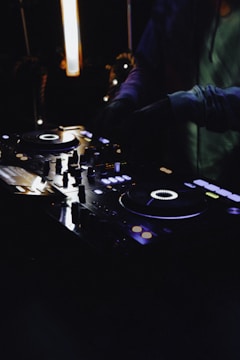 person in black jacket playing dj controller