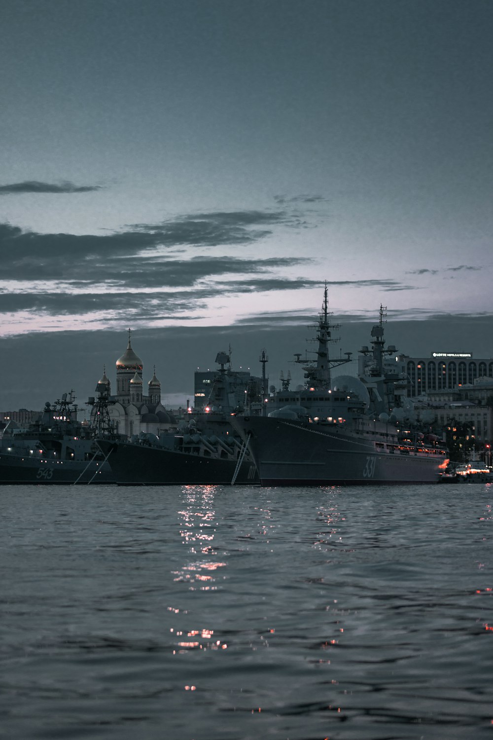 black ship on sea under white clouds during daytime