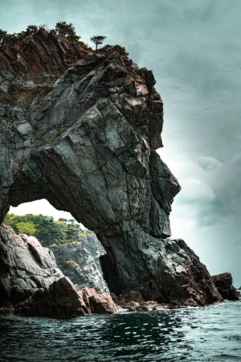 brown and gray rock formation under white clouds during daytime