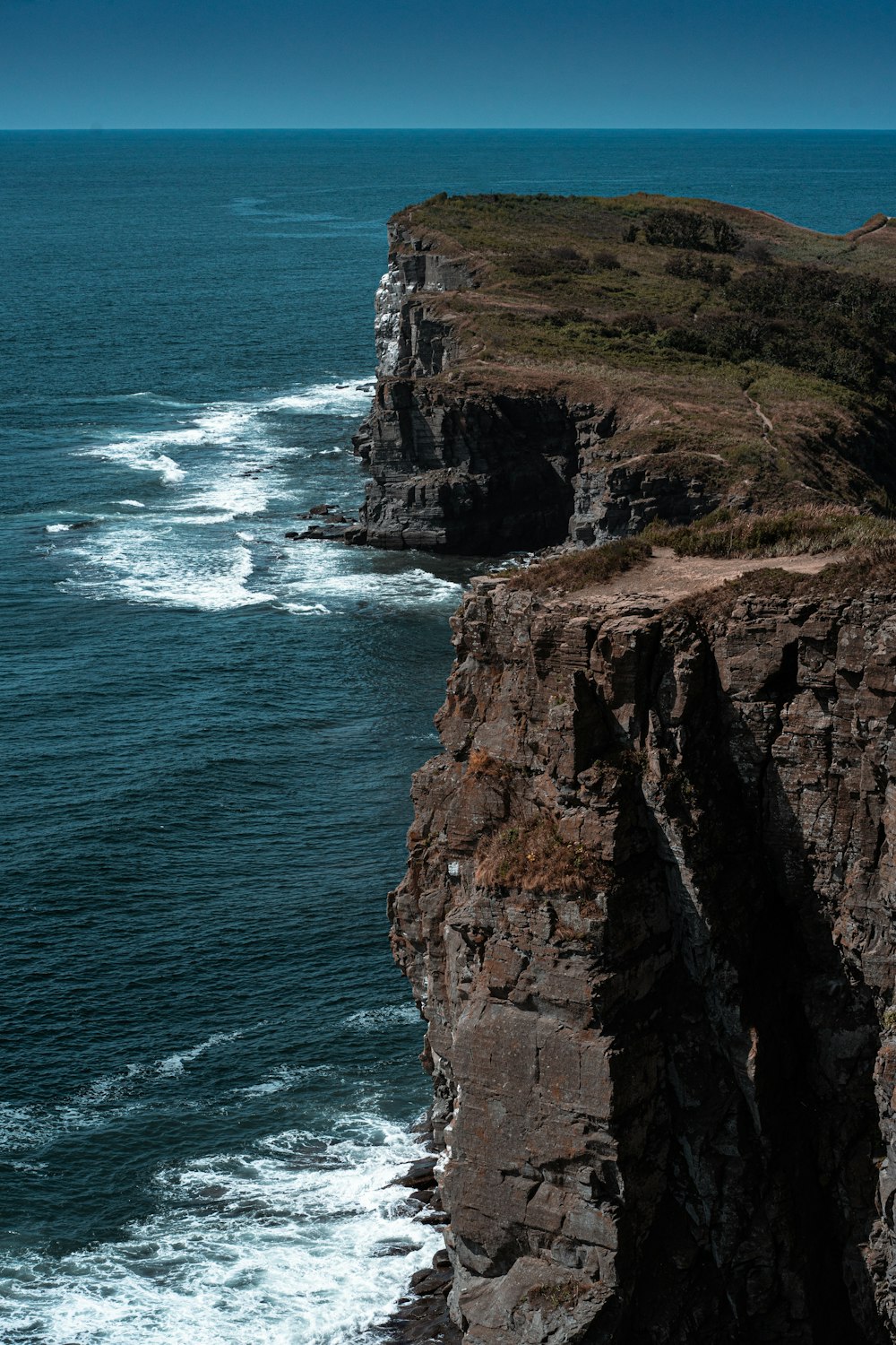 brown rock formation beside body of water during daytime