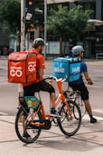 man in orange shirt and blue denim shorts riding on bicycle