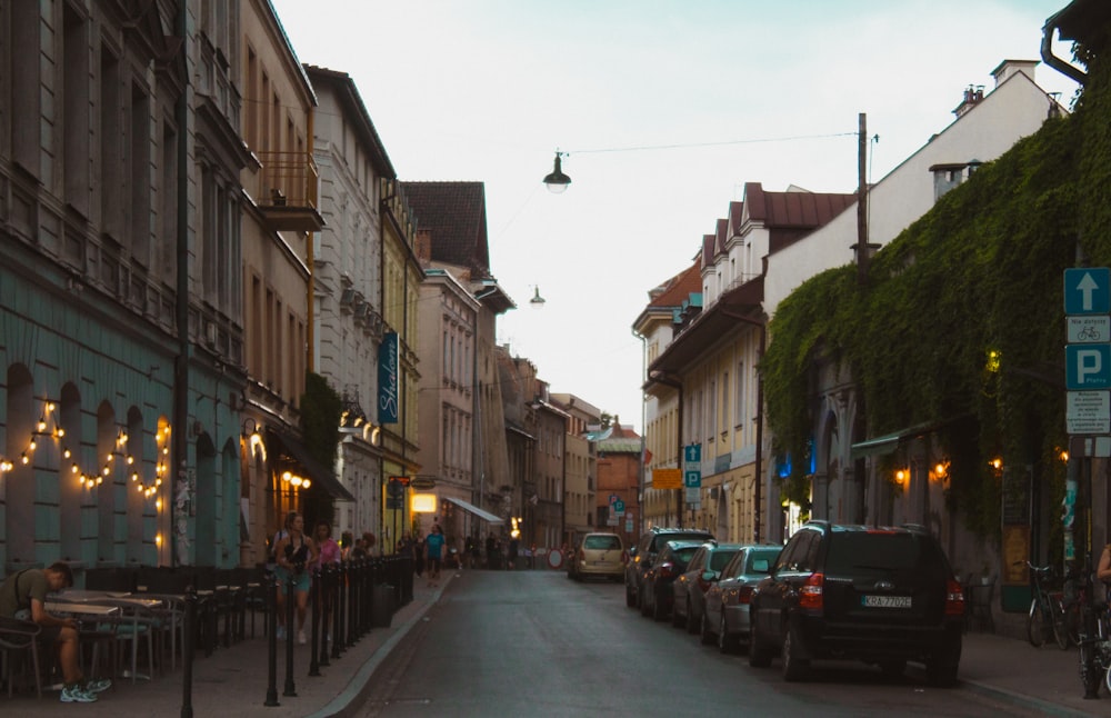 cars parked on side of the road in between buildings during daytime