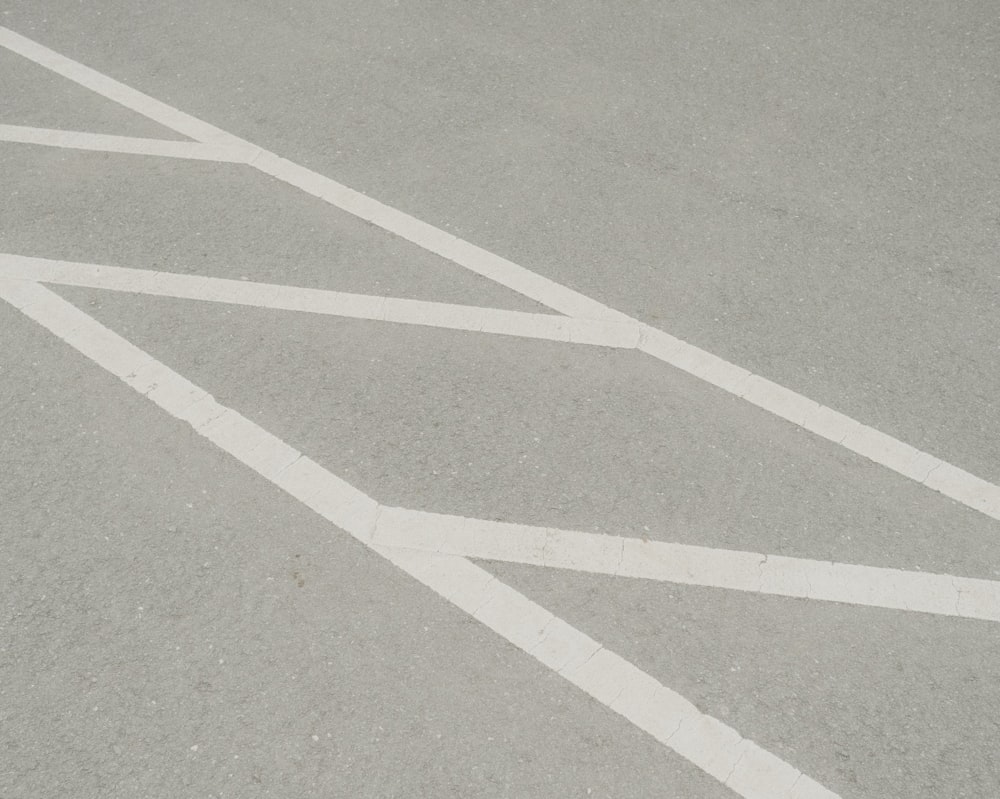 white arrow sign on gray asphalt road