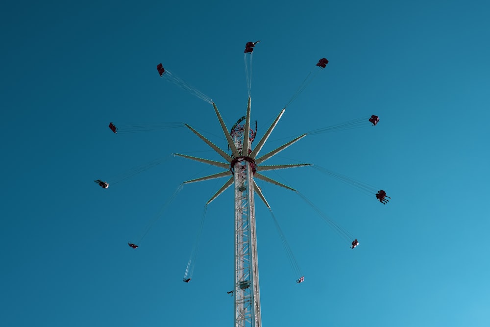 low angle photography of white and red ferris wheel under blue sky during daytime