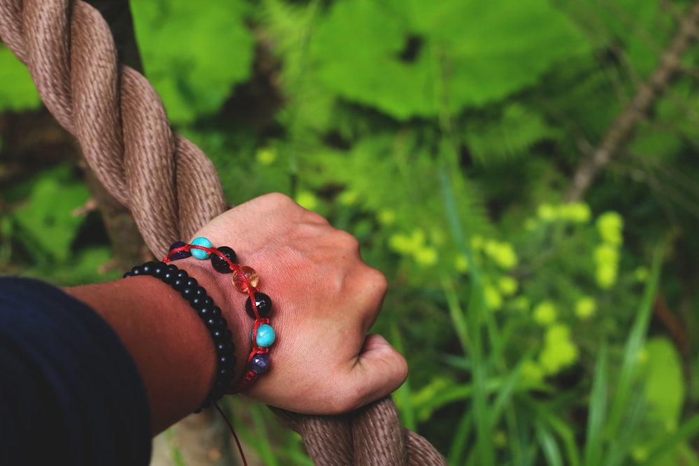 person wearing black and red bracelet