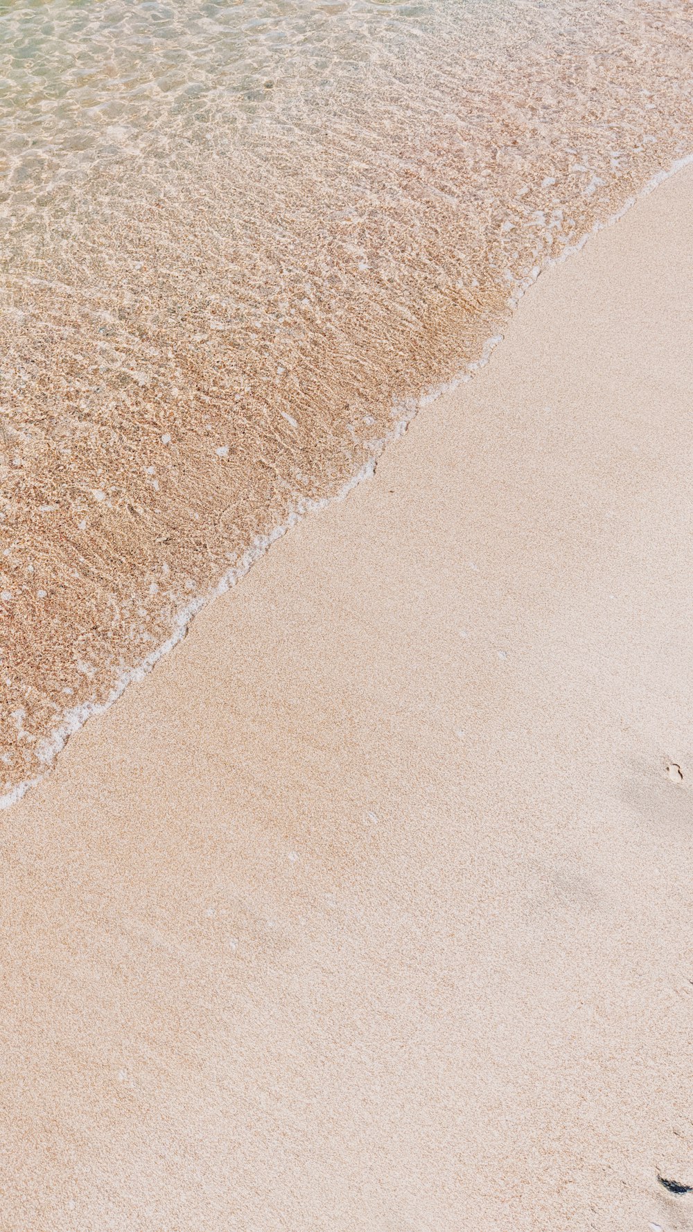 brown sand near body of water during daytime