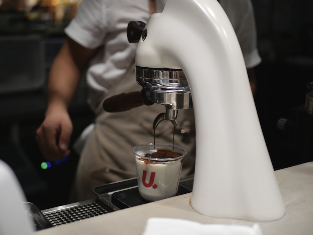 person pouring coffee on white ceramic mug