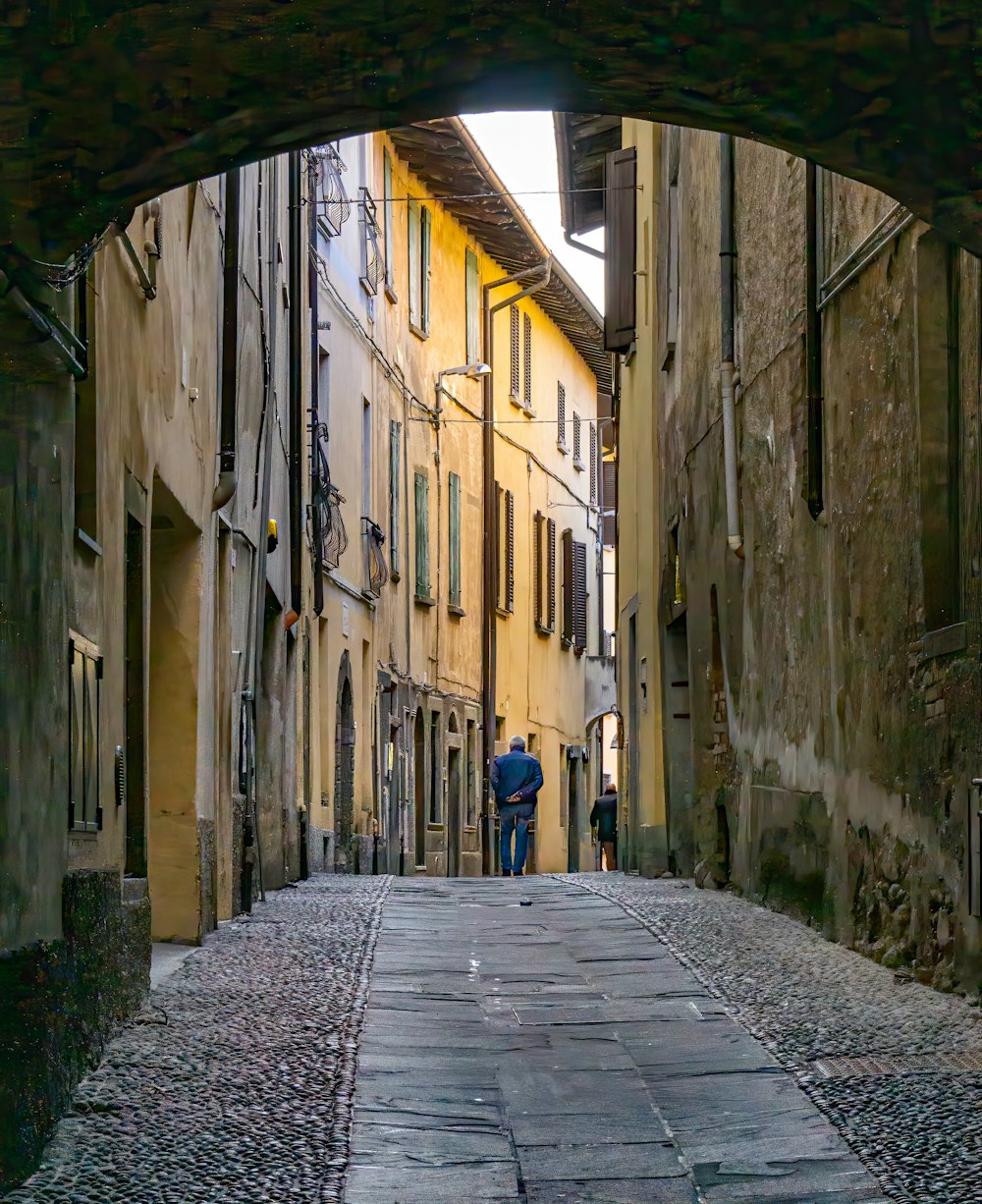 person in blue jacket walking on street during daytime