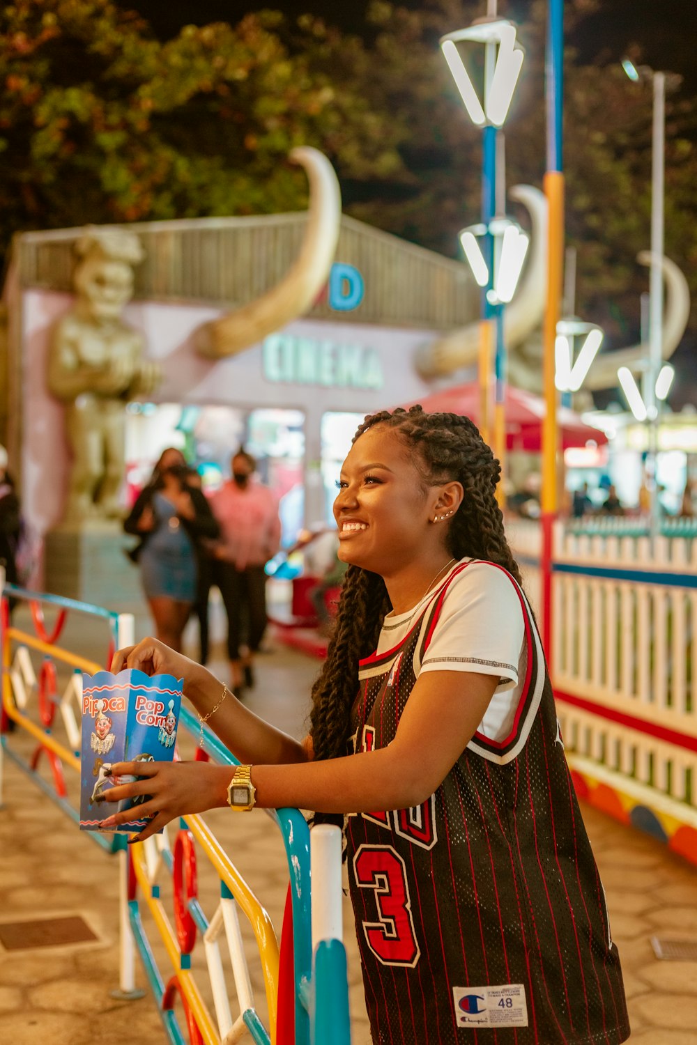 woman in black and white shirt holding blue and white plastic cup