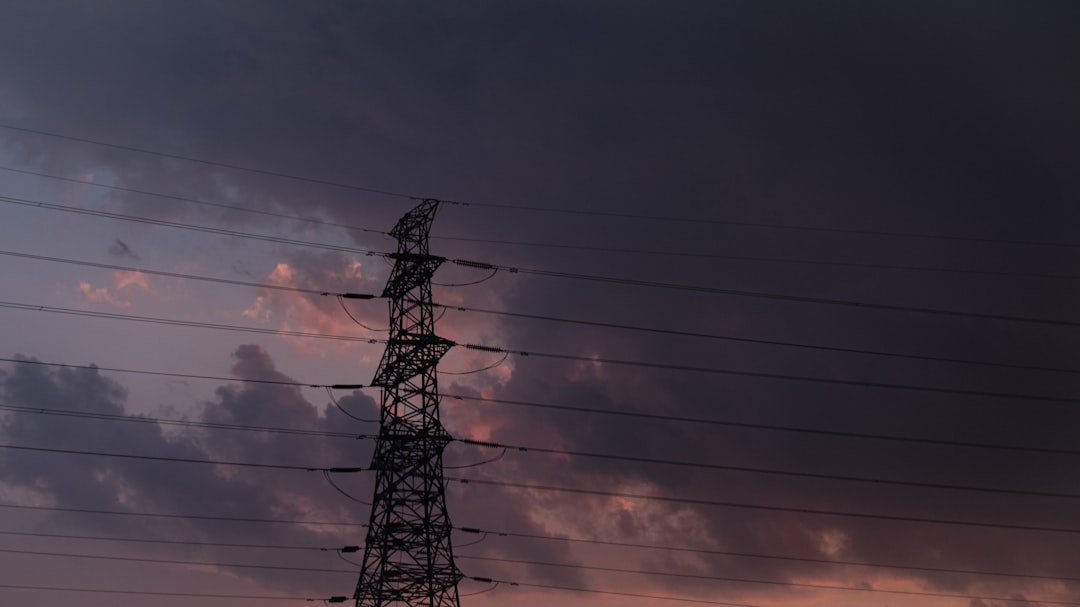 black electric tower under cloudy sky