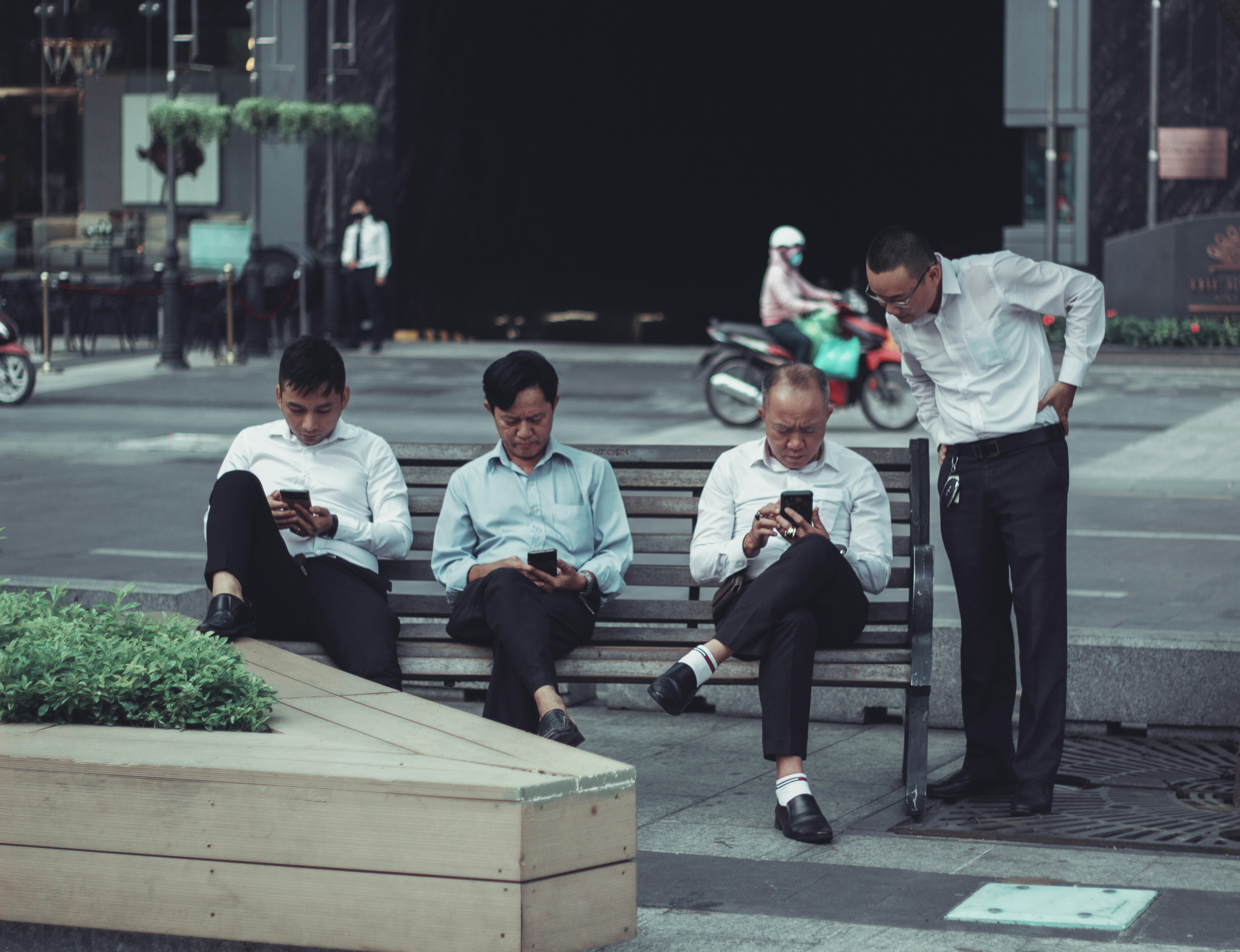 3 men sitting on bench during daytime