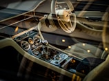 A luxurious car interior featuring a meticulously designed dashboard with chrome accents and a high-end steering wheel. The gear shift is prominently displayed, surrounded by elegant controls and dials. The seating is crafted from premium leather, with visible stitching for added detail.