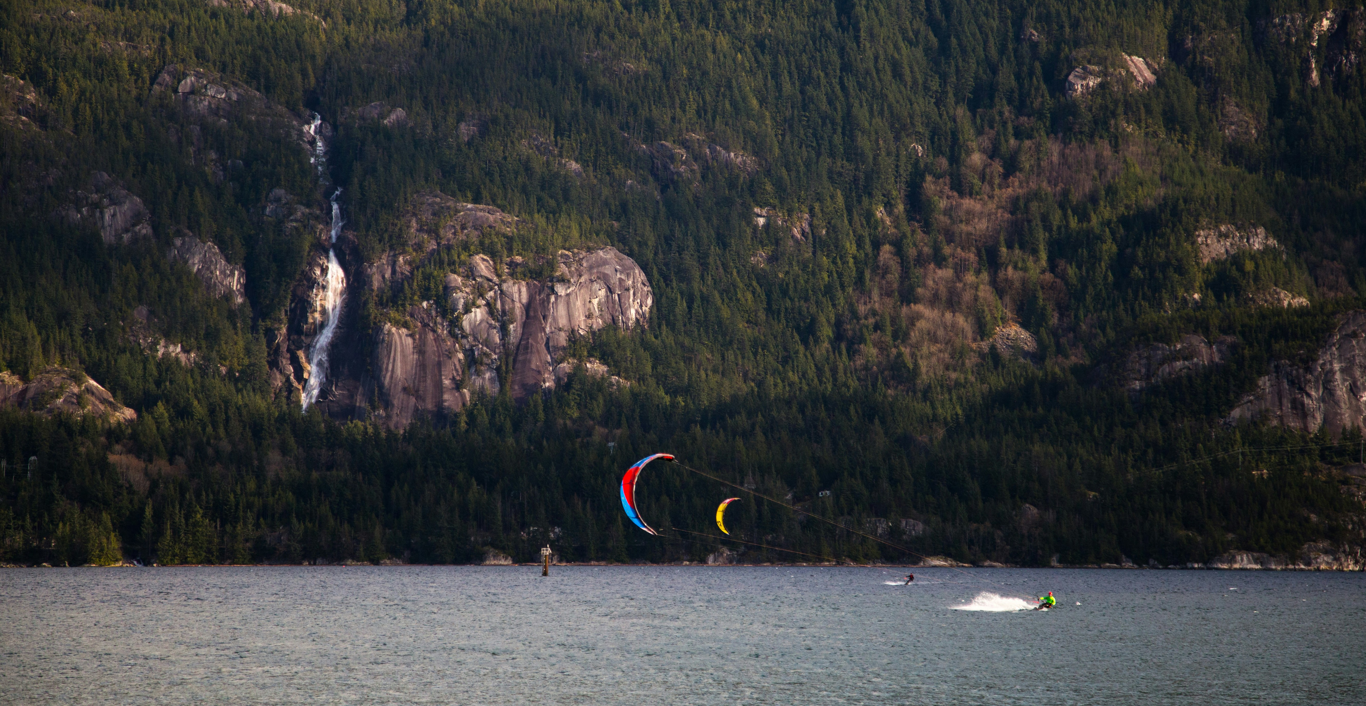 person riding on boat on sea near mountain during daytime