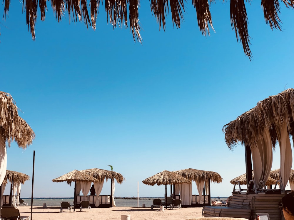 brown wooden beach umbrellas on beach during daytime