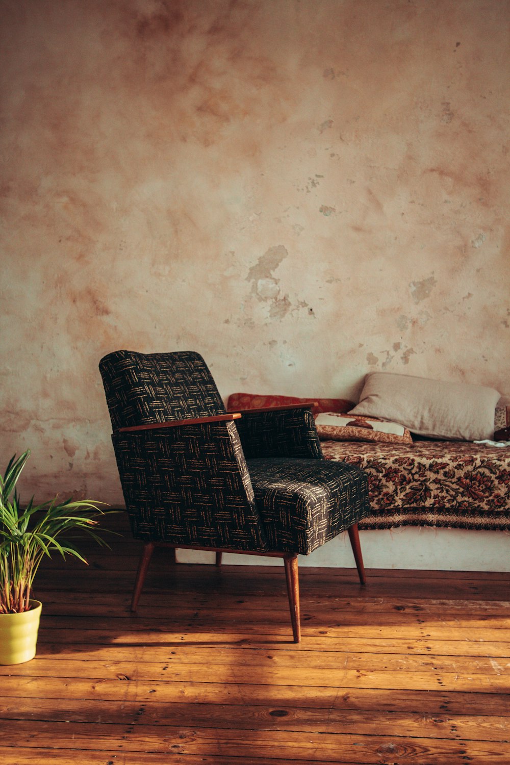 black woven armchair beside white and brown floral couch
