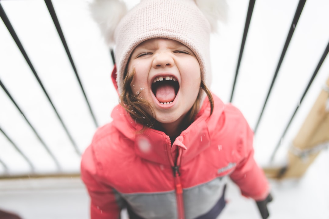 girl in red zip up jacket and white knit cap