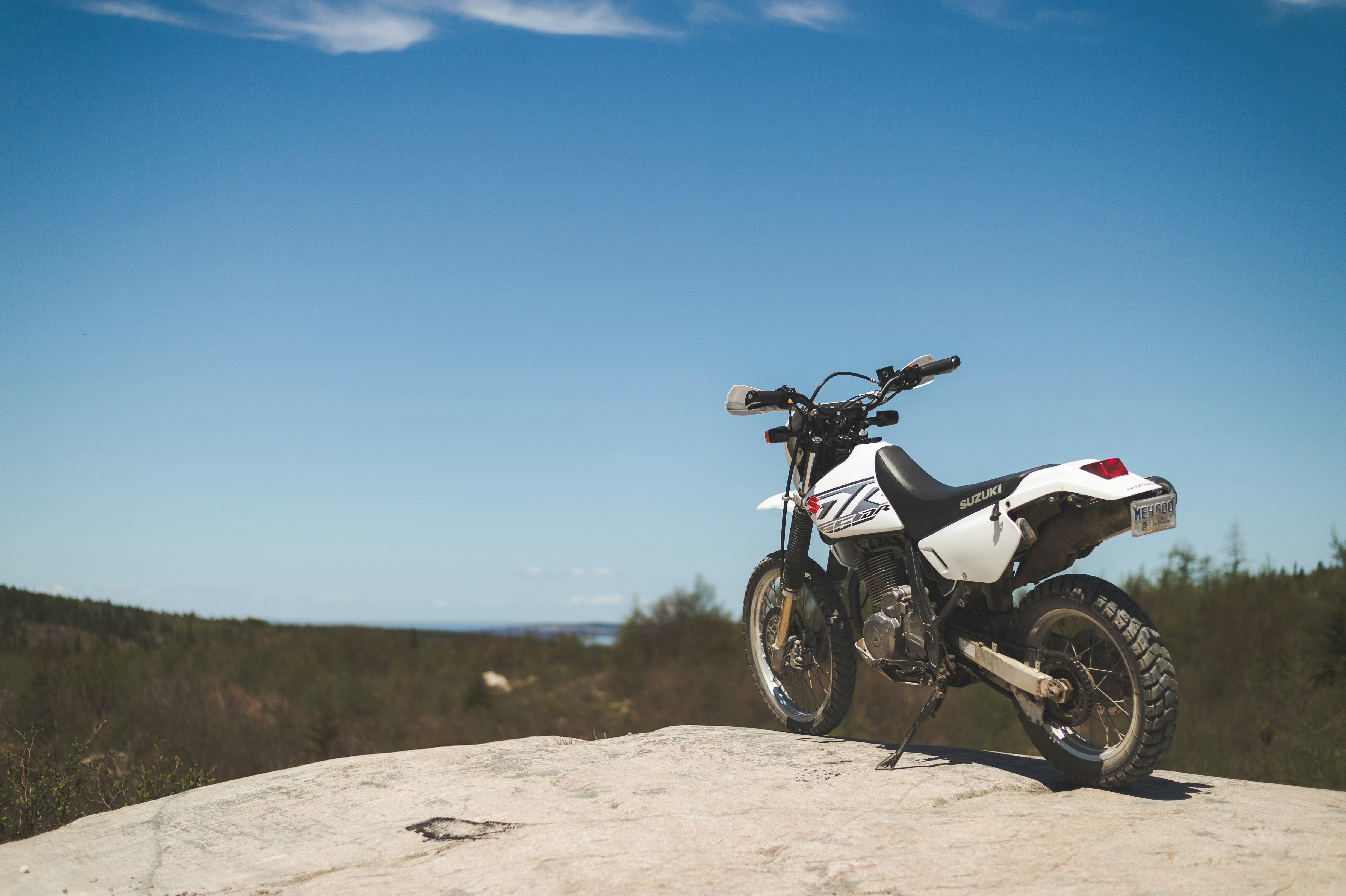 white and black motorcycle on brown sand under blue sky during daytime, 