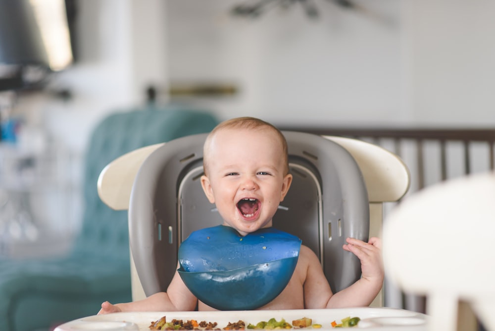 bébé couché sur une baignoire blanche et bleue