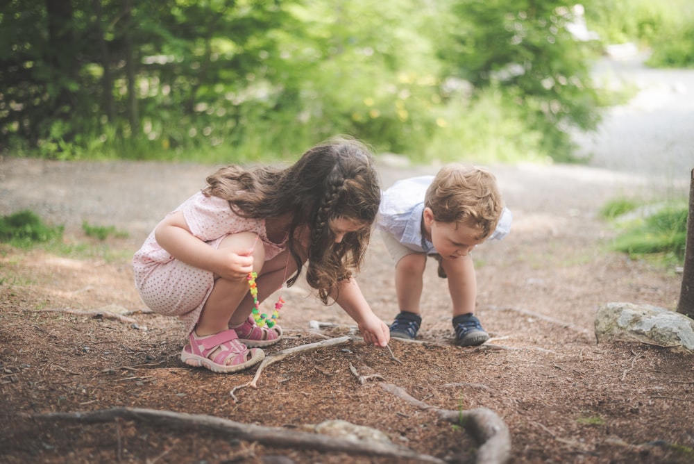 2 girls sitting on ground during daytime