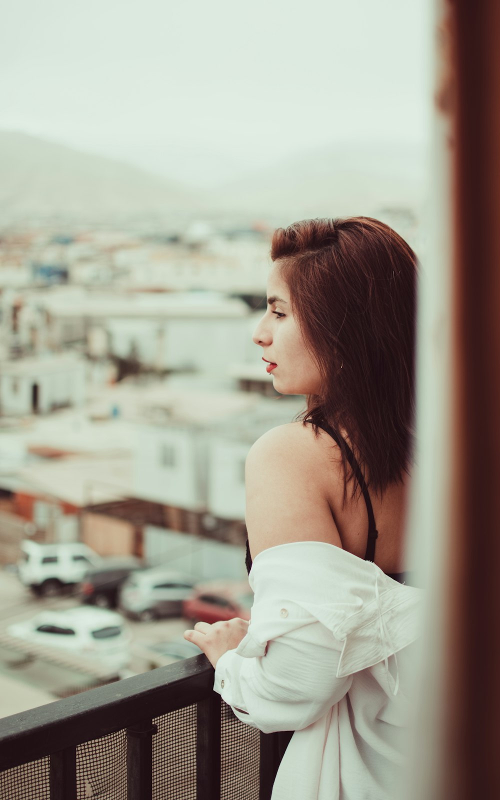 woman in white off shoulder dress looking at the city during daytime