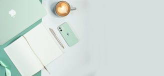 An overhead shot of a desk with coffee, notebooks, and colorful pens.