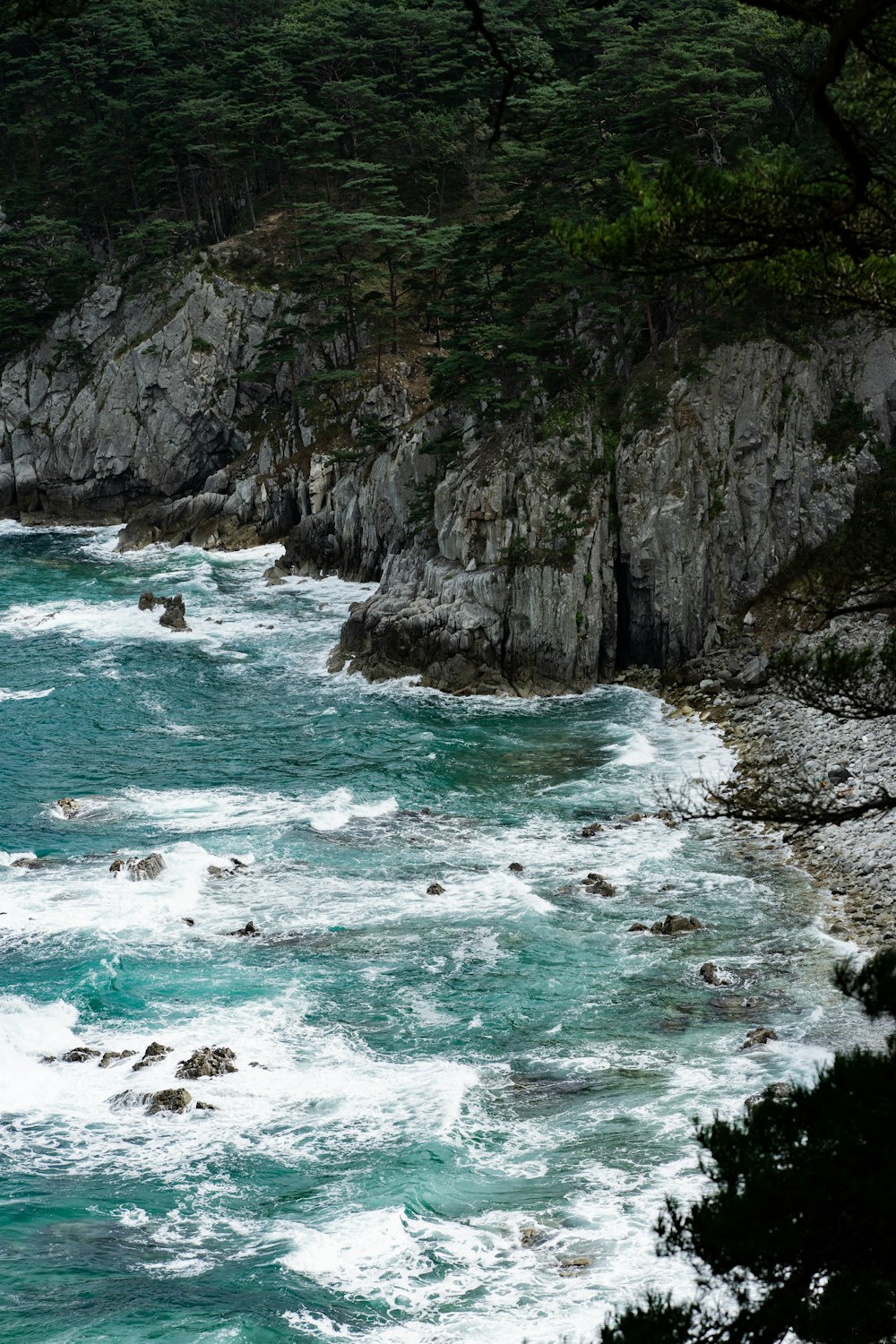 brown and green mountain beside body of water during daytime