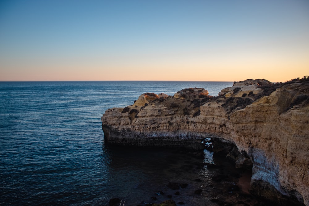 brown rock formation on sea during daytime