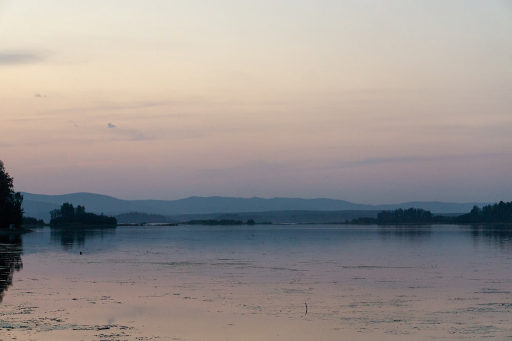 body of water near mountain during daytime