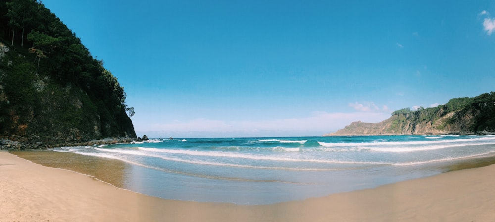 person standing on beach shore during daytime