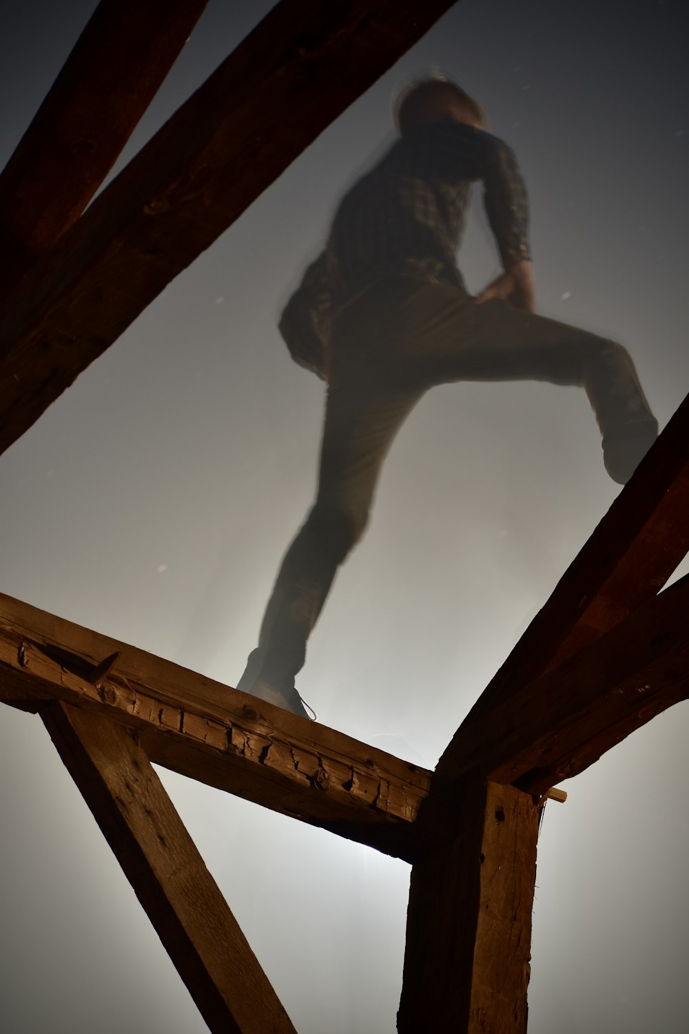 woman in black tank top and black pants climbing on brown wooden ladder