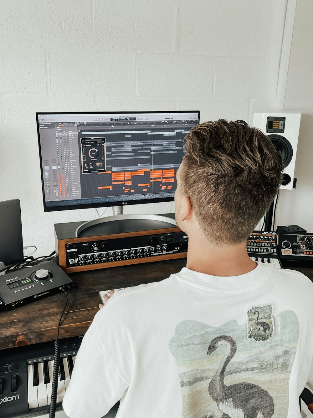 man in white crew neck t-shirt sitting in front of computer