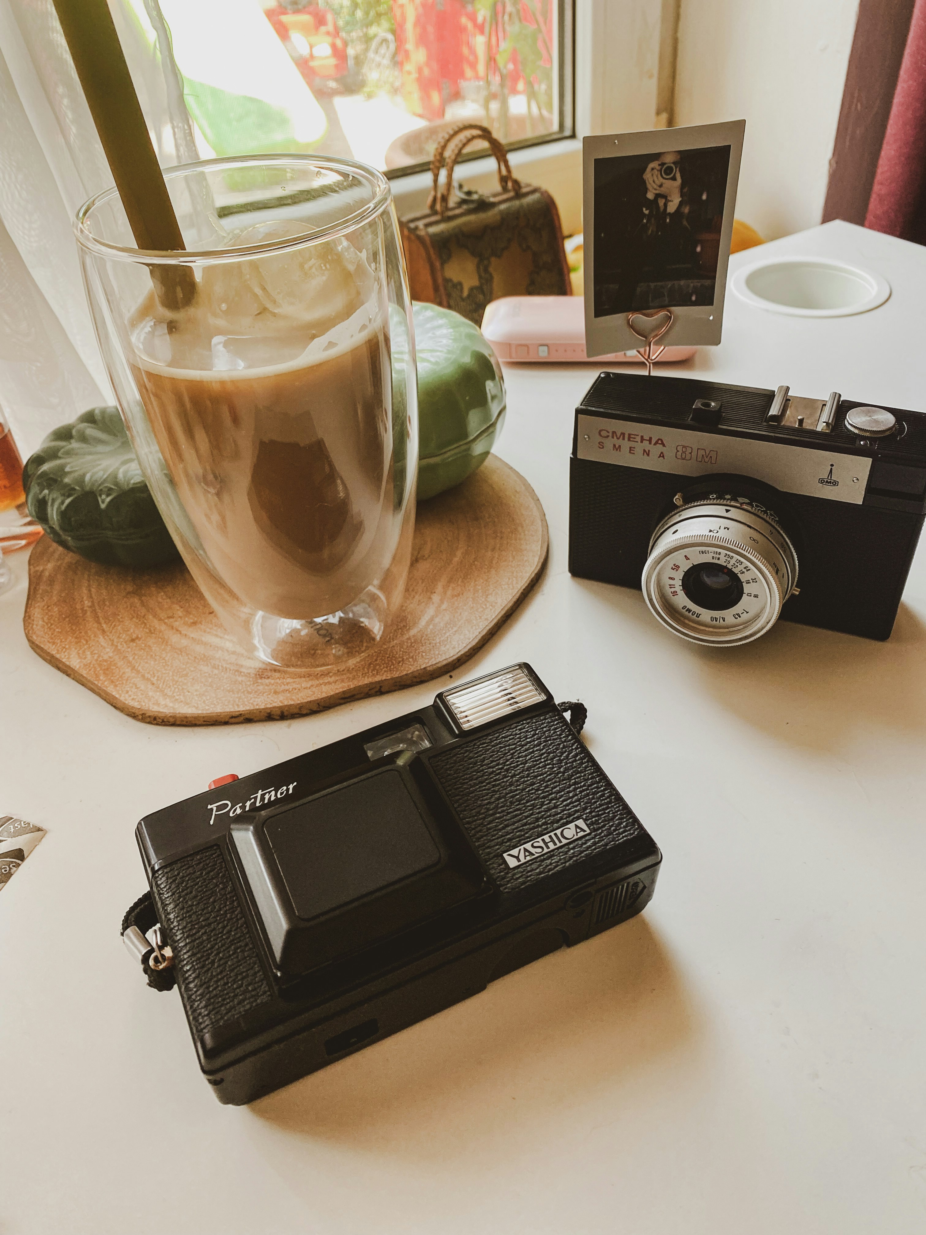 black and silver camera beside clear drinking glass