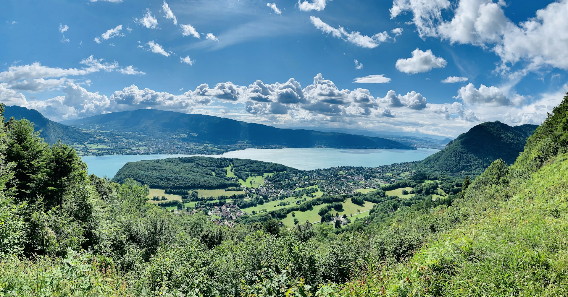 green trees and mountains under blue sky and white clouds during daytime