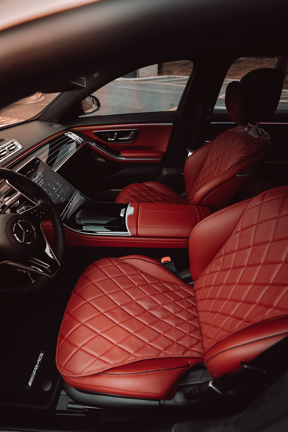 A car interior with red and black upholstered seats